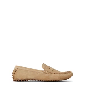 Rocky from KG Kurt Geiger is a slip-on shoe in a penny loafer style, featuring a beige suede upper.