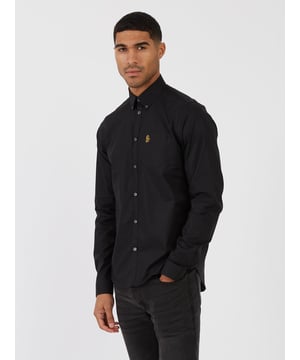 This classic LUKE long sleeved shirt is an essential item for your wardrobe, classically styled with a buttoned-down collar and a simple chest patch pocket. It is detailed with imitation river shell plastic buttons on the central front placket, running from hem to collar and is completed with the brand's iconic lion head embroidery on the left chest. Tailored fit. Iconic LUKE BLACK, GOLD, RED lion head embroidery. Iconic LUKE tri-colour trim tape. Left chest pocket detail-Imitation river shell plastic buttons. Central front placket. Button down collar detail at front and central at back. Back yoke detail and external back box pleat. Long sleeve with buttoned cuff.