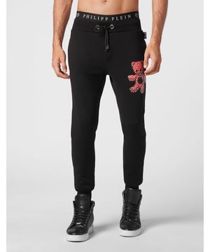 Joggins de felpa de algodón con inserciones acolchadas y una insignia de Teddy Bear aplicada en el lado izquierdo. Dos bolsillos de ranura en la parte frontal y uno en la parte trasera. Cintura de canalé con cordón de ajuste. Bajo de canalé tipo puño.