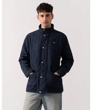 This windcheater jacket, crafted in a diamond quilted pattern, is made entirely from recycled polyester with a water-repellent finish. Designed in a mid-length regular fit, it features a stand collar and a front placket with press buttons over a hidden zip closure. Additional details include side hand-warmer pockets, lower flap pockets, and two interior pockets. Finished with branded embroidery at the chest and back locker loop, this jacket combines functionality with style. 


Regular fit
Mid-length
Water-repellent (DWR treatment)
Diamond quilted design


 Shell - 100% Recycled Polyester, Lining - 100% Recycled Polyester, Body -100% Recycled Polyester 

7006497
 
 