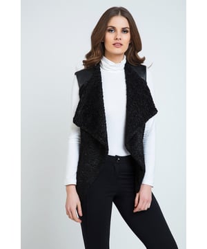 Mouwloos wintervest. Stof in Astrakan-stijl aan de voorkant, pleather op de schouders en stretch Punto di Roma aan de achterkant. Twee zakken aan de voorkant.  Gevoerd. Lengte voor maat 38: 60cm. Ons model is 178cm en draagt maat 36.