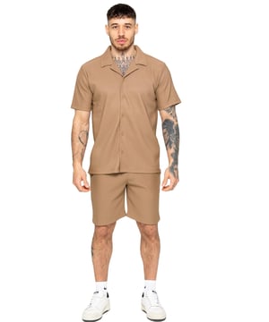 Verhoog je zomerse stijl met onze Enzo Milano Heren Outfit Set, inclusief een geribbelde revere shirt met textuur en relaxte pasvorm shorts. Ervaar ultiem comfort met een knoopsluiting en verstelbare trekkoord tailleband, terwijl je er moeiteloos stijlvol uitziet met een revere kraag en enkele achterzak met paspel. Gemaakt van premium stof, is deze set perfect voor elke gelegenheid