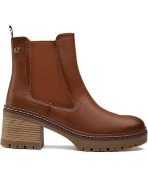 Botas de mujer Xti con cremallera interior en color tostado, fabricadas con material sintético y suela de goma. Incluyen: cremallera interior, refuerzo elástico, marca Xti, forro completo y 100 % vegano.