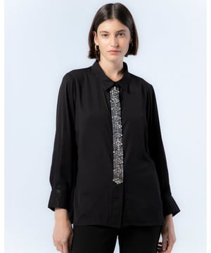 Atrévete con la camisa negra de pedrería Lucía. Con el detalle de las pedrería en el centro de la prenda, la camisa Lucía se convierte en tu mayor aliada para looks de noche este invierno.
 
 
 
 Camisa con cuello solapa.
 
 Detalle de pedrería plata en tapete.
 
 Manga larga acabada con puño.
 
 Forro de satén por separado.