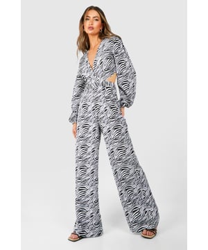 Striking zebra print pattern for a bold, eye-catching look
        Flattering wrap-style design with a plunging V-neckline
        Daring cut-out details at the waist add a touch of allure
        Wide-leg silhouette for a dramatic, flowing effect
        Long, billowing sleeves create an elegant, feminine silhouette
    
    Make a statement on your next night out with this show-stopping zebra print jumpsuit. The wrap-style design and plunging V-neckline create a flattering silhouette, while the daring cut-out details at the waist add a sultry touch. The wide-leg trousers and billowing sleeves offer a dramatic, flowing effect that's perfect for dancing the night away. Style this bold piece with strappy heels and statement earrings for a head-turning look at the club. For a more casual approach, pair it with flat sandals and a denim jacket for drinks with friends. The versatile design allows for endless styling options, making it a go-to choice for various social occasions. Whether you're hitting the town or meeting new people, this jumpsuit is sure to turn heads and boost your confidence.