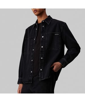 Mens Calvin Klein Regular-Fit Linear Denim Shirt in denim.- Pointed collar.- Branded metal snap buttons.- Patch chest pockets.- Barrel cuffs  curved hem.- Calvin Klein logo patch on the chest pocket.- Mid-weight cotton denim.- Regular fit.- Ref: J30J3268351BY