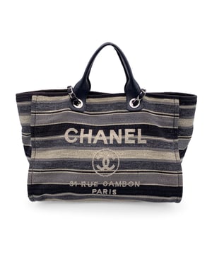 VINTAGE, RRP AS NEW
Beautiful Chanel 'Deauville' tote, crafted in black, grey and beige striped canvas with a white 'Chanel CC31, Rue cambon - Paris' logo. Period/Era: 2018/2019. Double black eather top handles and silver metal and interwoven leather shoulder straps. Magnetic button closure on top. The interior is in beige canvas lining. 2 side zip pockets inside. Leather strap with hook inside. 'CHANEL - made in Italy' tag inside. ity hologram tag inside Condition Rating: B - VERY GOOD CONDITIONCondition Details: Gently used. Some normal wear of use on bottom corners. Some darkness, small stains and normal wear of use on the internal lining. The fabric of the upper border is slightly discolored. Please, check carefully the photos or ask if you have any doubts. Measurements (cm):Depth: 20.3Height: 25.4Length: 43.2Other Details: Dustbag? NoKeys? NoBox? NoMeasurments:  width: 203 mm length: 432 mm height: 254 mm