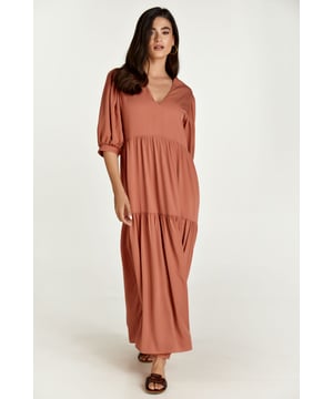 Deze terracotta maxi-jurk is gemaakt van cupro-stijl stof. Het model heeft elleboogpofmouwen met plooitjes op de schouders en manchetten. Het heeft een diepe V-halslijn. Er zit dubbele stof aan de bovenkant van de jurk voor een perfecte pasvorm. Er zijn twee verticale naden op het lijfje met plooitjes eronder voor een ruche-effect. De jurk heeft een ontspannen los silhouet.