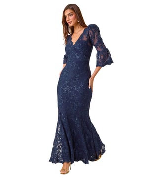 Lace Scallop V-Neck Bodycon Maxi Dress from Roman. Feel elegant and sophisticated in our stunning lace bodycon maxi dress, perfect for the Autumn Winter season. The feminine v-neckline is adorned with delicate scalloped lace details for a touch of romance. Designed in a flattering bodycon shape, this dress is crafted and lined from a comfortable woven fabric, finishing at maxi length with long sleeves to keep you warm at your next special occasion. Style with heels and a bolero for a truly unforgettable outfit!