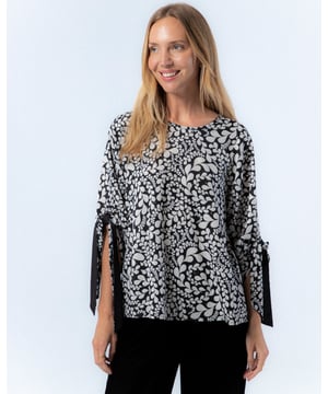 La blusa blanca y negra Paula te hará sentir cómoda y elegante. Esta blusa blanca y negra es la prenda que no puede faltar en tu armario este invierno.
 
 
 
 
 
  Blusa holgada con cuello redondo. 
 
 
 
 Cierre en espalda con abertura y botón. 
 
 Manga por debajo del codo con lazo confeccionado en mismo tejido y cara interna con tejido color negro. 
 
 
 
 Tejido estampado blanco y negro con foil dorado.