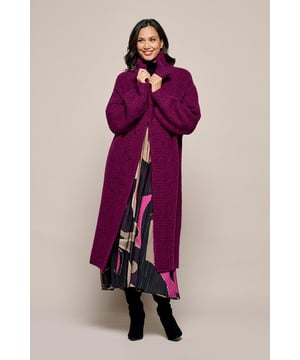 Het Evelyn vest in dark berry is een schitterend lang gebreid vest met een openvallend design en grove ribboorden. Dit vest heeft een losse pasvorm die net boven de kuit valt, waardoor je zowel stijl als comfort ervaart. De afneembare strikceintuur kan naar wens worden gebruikt om de taille te accentueren. Gemaakt van een luxe wolmix met 30% acryl, 25% gerecycled acryl, 25% wol en 20% gerecycled polyester, biedt het vest optimale warmte en comfort voor koude winterdagen. Het grof gebreide wol zorgt voor een zachte en warme uitstraling. Met zijn lange lengte en trendkleur dark berry is dit vest een veelzijdig en stijlvol kledingstuk dat perfect je wintergarderobe aanvult. De hoogwaardige materialen garanderen zowel comfort als elegantie.