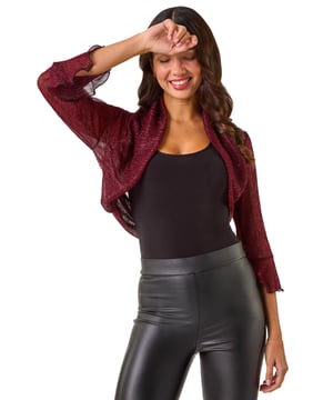 Plisse Jersey Bolero from Roman. Add a touch of glamour to your outfit with this chic bolero. Crafted from a shimmering metallic jersey plisse fabric, this cropped bolero features elegant 3/4 fluted sleeves and an edge to edge design. The bolero shape is perfect for layering over a simple t-shirt and jeans to instantly elevate your look. Perfect for Autumn/Winter, this piece is a must-have for adding a touch of sparkle to your wardrobe!