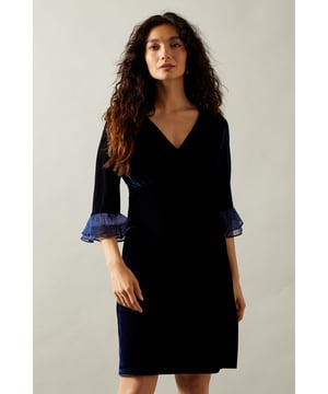 Luxurious velvet fabric for a sophisticated touch
        Flattering V-neckline enhances the dcolletage
        Elegant pleated cuffs add a unique flair
        Mini length perfect for showcasing legs
        Three-quarter length sleeves with contrasting sheer detail
    
    Make a statement at your next soire with this captivating velvet mini dress from Wallis. The sumptuous fabric drapes beautifully, creating a figure-flattering silhouette that's both comfortable and chic. The V-neckline draws the eye, while the pleated cuffs with sheer detailing add a touch of drama to your ensemble. Perfect for cocktail parties or evening events, this dress can be styled with strappy metallic heels and a clutch bag for a glamorous look. For cooler evenings, layer with a sleek blazer or wrap. The versatile design allows for easy transition from day to night, making it an essential piece for the fashion-forward woman who values both style and comfort.