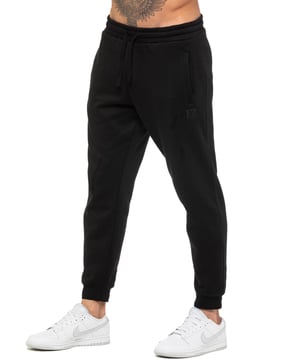 Enzo Mens Regular Fit Joggers. Elasticated Waistband With Adjustable Drawstring. Features 2 Side Slash Pockets & Single Welt Back Pocket. Cuffed Ankle. Features EZ Logo.