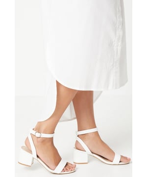 Wide fit design offers a comfortable and accommodating fit
Barely-there strappy silhouette with minimalist appeal
Mid block heel provides a modest lift and walkable height
Faux leather upper exudes a look and feel
Ankle strap with buckle closure ensures a secure fit

These versatile sandals are perfect for casual daytime outings or relaxed evening affairs. Pair them with a flowy midi dress or cropped trousers for a chic, on-trend look that transitions seamlessly from brunch with friends to an evening baby shower. The neutral hue complements a variety of ensembles, allowing you to showcase your personal style effortlessly.