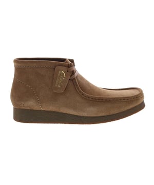 Las botas Clarks Wallabee para hombre en color marrón son una opción clásica y elegante para los hombres que buscan una combinación de comodidad, calidad y diseño atemporal. Clarks es famosa por su compromiso con la fabricación de calzado cómodo y bien hecho, y las botas Wallabee no son una excepción. Aquí tienes una descripción de las principales características:

 Color marrón intenso: Estas botas se presentan en un intenso color marrón, ofreciendo un aspecto cálido y versátil que complementa una amplia gama de atuendos, desde informales a semiformales. Las botas marrones son una opción clásica para los hombres.

 Parte superior de ante o piel de primera calidad:  Las botas Wallabee se fabrican normalmente con una parte superior de ante o piel de primera calidad, que proporciona tanto calidad como un aspecto elegante. La posibilidad de elegir entre ante y piel le permite seleccionar el material que mejor se adapte a su estilo y necesidades.

 Diseño inspirado en los mocasines:  Las botas Wallabee presentan un diseño inspirado en los mocasines, caracterizado por el distintivo pespunte de la puntera en forma de mocasín. Este diseño añade un toque de sofisticación y estilo a las botas.

 Cierre de cordones: Estas botas suelen tener un cierre de cordones, que permite un ajuste seguro y regulable. Los cordones añaden un aspecto atemporal y versátil.

 Suela de crepé: Las botas vienen con una suela de crepé, conocida por su comodidad y amortiguación. Proporciona una excelente absorción de impactos y reduce la fatiga, lo que las hace cómodas para un uso prolongado.

 Cordones clásicos de dos ojales:  El sistema de cordones de dos ojales es una característica clásica de las botas Wallabee, que se suma a su estilo tradicional y atemporal.

 Estilo versátil:  Las botas Clarks Wallabee marrones para hombre tienen un estilo versátil que puede combinarse con varios atuendos, lo que las hace adecuadas tanto para ocasiones informales como semiformales.