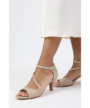 Step into wedded bliss with these stunning Loreza Low Kitten Heel with Crossover Strap. Perfect for the bride who desires both style and comfort on her special day, these sandals offer a luxurious finish that radiates elegance. Ideal for the wedding ceremony and reception, these versatile sandals can be paired with a flowing bridal gown or a chic cocktail dress for the after-party. These sandals are not just for the big day - they're perfect for other formal occasions, adding a touch of bridal glamour to any ensemble.
Key Features:


Pointed Toe: The pointed toe of these heels adds a touch of sophistication and elegance to your look. It creates a sleek and stylish silhouette that can elevate any outfit.

Low Kitten Heel: The low kitten heel provides the perfect amount of height without sacrificing comfort. The buckle fastening offers stability and support, allowing you to confidently walk and stand for extended periods.

Crossover Strap: The crossover strap detail adds a trendy and modern element to these heels. It not only enhances the visual appeal but also provides additional support and security, ensuring a comfortable fit.

Durable Construction: These heels are made from high-quality materials that are built to last. The sturdy construction ensures durability and longevity, allowing you to enjoy these stylish heels for years to come.

Specifications:

Material: Glitter
Design: Pointed toe low kitten heel with crossover strap

Closure: Buckle
Luxurious glitter finish for a glamorous bridal look

Step up your style game with our Loreza Low Kitten Heel with Crossover Strap. These heels offer a combination of fashion and comfort, allowing you to showcase your unique style while staying comfortable throughout the day. Add a touch of elegance to any outfit with these versatile and stylish heels.