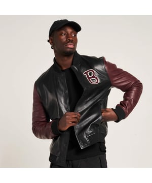 Introducing the Barneys Originals Varsity Bomber Jacket – a fusion of athletic charm and urban sophistication. With its sleek black body and striking burgundy sleeves, this jacket effortlessly channels vintage-inspired style with a contemporary twist. Perfect for adding a touch of sporty flair to any ensemble, it's a versatile staple for your wardrobe.