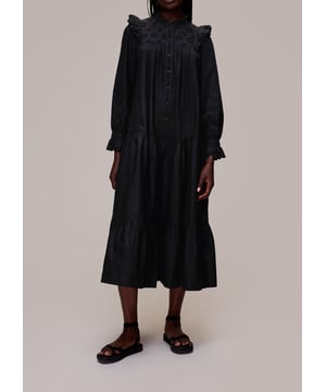 Discover the Talula Dress, your go-to for evening sophistication. This black trapeze dress, crafted from soft 100% cotton, features long sleeves and exquisite broderie accents. Its flowing design ensures a graceful silhouette and comfort for any occasion.