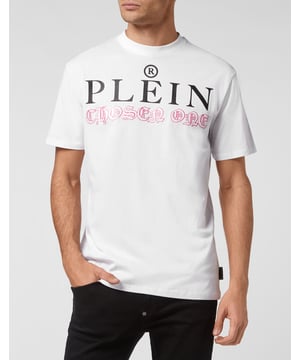 Mire cómo se transforma esta camiseta de jersey de algodón con cuello redondo. La prenda lleva el icónico estampado de las letras de la marca y una frase irónica al más puro estilo Plein. Un parche de cuero saffiano con el Hexágono PP está cosido en el canesú. Dobladillos de pespunte doble.