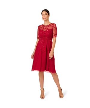 From cocktail hours to formal nights out, this midi dress is an effortlessly beautiful design. This party dress features a crew neckline, sheer short sleeves, and a soft, midi length skirt. Lined from the bust through the skirt, this cocktail dress boasts an illusion, sweetheart neckline. Overlaid with luxe mesh, this dress shows off hand-embroidered beading and sequins in vine and lattice designs. A zipper closure at the sheer centre of the back completes this beaded dress. Dress this look up with nude heels and a beaded clutch for a look beyond compare.