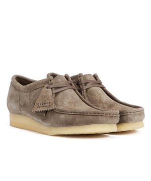 These shoes feature suede uppers, flat laces, and tonal fobs, marking Clarks' commitment to quality. They are complete with natural crepe soles, ensuring both style and comfort.