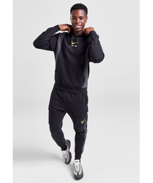 Nike Heren Paneel Trainingspak Cool Zwart. - - . Deze standaard pasvorm hoodie heeft een klassiek overhead ontwerp en is gemaakt van een zachte en ademende katoen-poly fleece stof voor langdurig comfort. - Hij is verkrijgbaar in zwart en grijs en heeft een verstelbare capuchon voor bedekking op maat en geribde boorden om de vorm vast te houden. - - . Met een kangoeroezak voor opbergruimte en het Nike Air logo op de borst. - - .  Eigenschappen Joggers Handige opbergmogelijkheden en ontspannen comfort. - - .  Het middelgewicht geborstelde fleece voelt extra zacht aan de binnenkant en glad aan de buitenkant, zodat je behaaglijk blijft terwijl het zijn gestructureerde vorm behoudt. - - .  Het throwback-logo en de felle kleuren zorgen voor een eenvoudige maar gedurfde stijl.