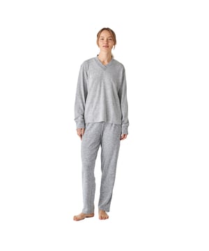 Pijama de mujer de manga larga con un diseño elegante y cómodo, ideal para descansar o relajarse en casa.

Su diseño moderno y sofisticado se adapta perfectamente a la figura femenina, realzando la silueta con un estilo chic y relajado.

El conjunto incluye una parte superior de manga larga con cuello en pico, que aporta un diseño cómodo y sencillo, ideal para un estilo relajado y versátil. Además, cuenta con dos prácticos bolsillos, que añaden funcionalidad sin comprometer el estilo.

El pantalón largo tiene un ajuste holgado y una cintura elástica ajustable mediante cordones para mayor comodidad. También incluye prácticos bolsillos laterales, perfectos para llevar pequeños objetos o simplemente para añadir un toque funcional al diseño.

Toda la pijama está confeccionada con un tejido suave y transpirable, perfecto para cualquier época del año, garantizando frescura y confort durante el descanso.
 Composición: Camiseta: 72% Poliéster, 23% Viscosa, 5% Elastano; Pantalón: 72% Poliéster, 23% Viscosa, 5% Elastano
 Cuidados:
- Lavar en máquina máx 30ºC.
- Centrifugado corto.
- No usar secadora.
- Planchar máx 110ºC.