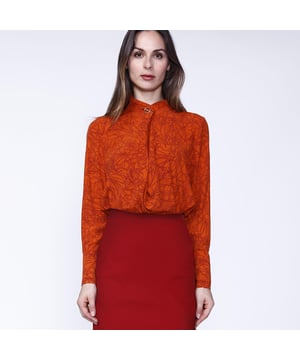 Eine originelle Bluse mit dezentem, linearem Blumendruck in leuchtenden Farben. Der asymmetrische Kragen ist mit einem goldenen Metallknopf verziert. Tragen Sie die Bluse zu einem schwarzen oder burgunderfarbenen Schneider bei der Arbeit oder zu einer Jeans für einen lässigen Look.
 
 Einzelheiten zum Produkt :
 Gerade Form
 Länge: 73 cm
 Lange Ärmel
 Gekreuzter Stehkragen