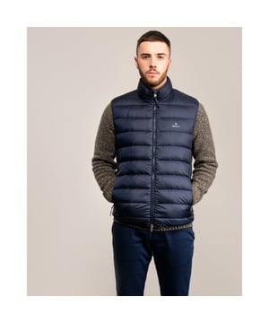 Designed for fall and winter layering, the Light Down Gilet will be your go-to vest when the temperature begins to drop. With a narrow, flattering fit and a high percentage of down (90% down, 10% feathers), this jacket is super lightweight, making it easy for traveling and layering. Wear alone in early fall, or under a wool jacket for additional insulation during the colder months for when the temperature drops to -10 degrees Celsius.

Regular fit
Two zip pockets at front
Two-way zipper
Printed GANT logo at front

Shell - Polyester 100%, Back Lining - Polyester 100%, Padding - Down 90%, Feathers 10%