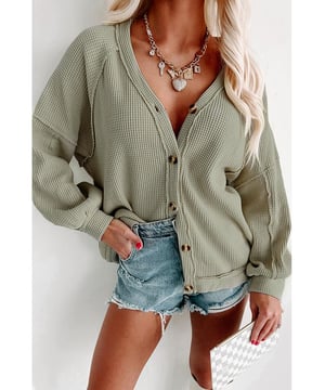 Luxuriöser grüner Cardigan mit sichtbaren Nähten und Knopfverschluss vorne  
Hergestellt aus hochwertigen Materialien  
Sichtbare Nähte für ein einzigartiges Design  
Knopfverschluss vorne für einfachen Tragekomfort  
Waffelstrick-Textur sorgt für Dimension  
Perfekt für Frauen, die zeitlose Eleganz und überlegene Handwerkskunst schätzen
