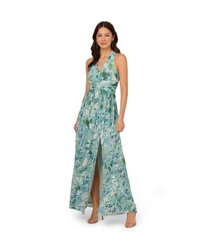 Pretty little details make this halter gown shine. This formal dress features a faux wrap bodice with halter neckline, shirred detailing at the waist surrounding a fabric-trimmed ring at the centre, and a flowing skirt with thigh-high slit. Fully lined, this dress is crafted from leaf-printed chiffon with shirred detailing through the skirt. A zipper closure at the centre back completes this evening gown. A pretty look for day or nighttime events, style this dress with nude heels and a sparkling clutch.