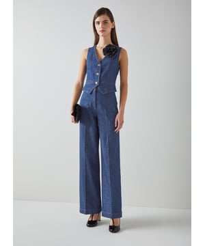 Teaming up with a fabulous pair of wide-leg denim trousers, the Ami waistcoat works as part of this tailored duo, but also with knits, tees and over summer dresses. Crafted from a super-soft organic cotton denim in mid-indigo with a hint of stretch, it's a V-neck style with a shapely cut that's pointed at the front and straight at the back, fastening with horn-effect buttons. Very playful and vintage-inspired, don't do the summer season with it.