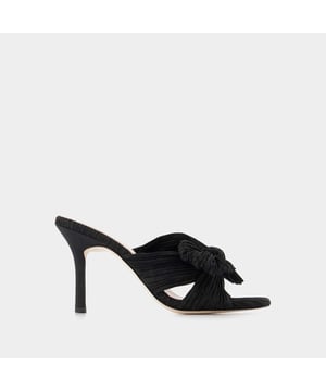 ¿Mules de terciopelo con un gran lazo en la parte delantera? El zapato de princesa por excelencia Póntelos con unos vaqueros anchos o un vestido largo.