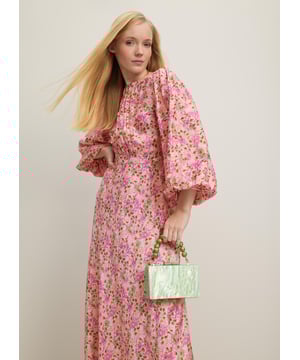 A beautiful new dress in our Royal Ascot collection, the Lois is pretty in pink with a reimagition of a French mid 19th century print. Crafted from a slinky viscose-silk blend in pink with a squiggle jacquard and a neon garden print, it has a round neck with pleating detail, puff shoulders, voluminous balloon sleeves and a long, floaty cut falling to a midi length. Wear it with heels and a hat to cheer on the winners.