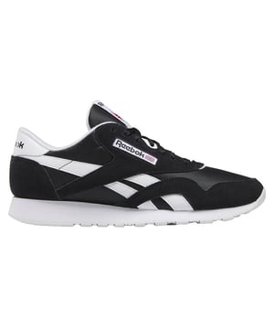 Las zapatillas de hombre Reebok Classic Nylon son una opción atemporal y versátil de calzado casual para hombre. La serie Classic Nylon de Reebok es famosa por su diseño retro y su comodidad. Aquí tienes una descripción de las características clave:

 Diseño clásico:  Estas zapatillas tienen un diseño clásico y atemporal, que ofrece un aspecto retro muy adecuado para una amplia gama de conjuntos y estilos informales.

 Parte superior de nailon y ante:  La parte superior suele estar hecha de una combinación de materiales de nailon y ante. El nylon aporta transpirabilidad, mientras que el ante añade durabilidad y estilo al diseño.

 Silueta de caña baja:  Estas zapatillas tienen un diseño de caña baja, que proporciona libertad de movimiento y un aspecto clásico adecuado para diversas ocasiones informales.

 Cierre de cordones: Las zapatillas tienen un cierre de cordones que permite un ajuste seguro y regulable. Los cordones garantizan que las zapatillas se mantengan ajustadas al pie durante el uso diario.

 Cuello y lengüeta acolchados:  Las zapatillas suelen tener el cuello y la lengüeta acolchados, lo que aumenta la comodidad y proporciona amortiguación en la zona del tobillo.

 Entresuela de EVA troquelada:  La entresuela troquelada de EVA (etilvinilacetato) ofrece una amortiguación ligera, garantizando una cómoda experiencia bajo los pies.

 Plantilla acolchada:  Muchas zapatillas Reebok, incluida la serie Classic Nylon, vienen con una plantilla acolchada que proporciona comodidad y apoyo adicionales para tus pies.

 Suela de goma duradera:  La suela exterior de goma está diseñada para una buena tracción y longevidad, asegurando estabilidad y agarre en diversas superficies.

 Marca Reebok:  El logotipo clásico de Reebok y los elementos de marca aparecen a menudo en estas zapatillas, añadiendo autenticidad y un toque deportivo al diseño.
