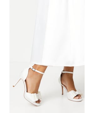 Exquisite satin upper with a structured bow detail
Elegant ankle strap with buckle fastening
Towering stiletto heel between 7-9cm in height
Peep-toe design showcasing your pedicure
Platform sole for added comfort and stability

Radiate sophistication at your next formal event with these stunning satin sandals from Coast. The structured bow detail and peep-toe design exude timeless elegance, while the towering stiletto heel and platform sole provide both style and comfort. Pair these sandals with a floor-length gown for a refined look that will turn heads at weddings, races, or any other special occasion.