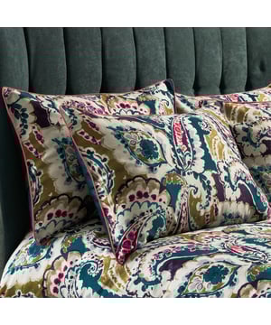 The Aretha pillowcases are a lively, contemporary take on a traditional Persian paisley print. Large scale paisley shapes curl around the cloth creating layers of vibrant, retro design. An intricate patterned design is digitally printed onto a luxury 200 thread count sateen cotton and finished with exquisite contrast piping. This creates a visually exciting pop of colour to accentuate the front design. The cotton sateen reverse adds to the tempting, luxurious space to rest your head each night.