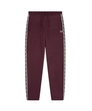 Burgundige Jogginghose mit Fred Perry-Logo, Markenlogo auf dem linken Bein, rote Jogginghose, elastische Taille und Bein. 46 % Baumwolle, 54 % Polyester, hergestellt in Portugal, rote Jogginghose