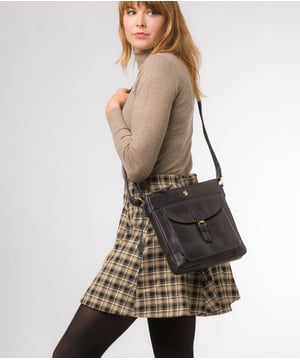 The 'Josephine' shoulder bag from Conkca London is crafted from vegetable-tanned leather for a richly textured finish. The zip-over top conceals a gorgeous, 100% natural, untreated cotton lining and two interior pockets. Featuring a mock buckle, the exterior pocket provides plentiful on-the-go storage. Comes with an adjustable fabric strap and is furnished with gold-coloured metal fittings. Adorned with the inimitable and charming Conkca London squirrel charm and logo for an eye-catching finish.