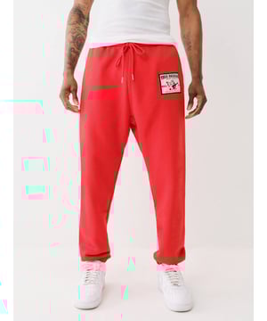 Elevate your cozy game in the Ladder Stitch Logo Applique Jogger. This pair of joggers features a front True Religion Buddha logo applique with ladder stitch trim. Finished with a drawstring waist, elasticized trim, and ladder-stitched horseshoe detailing on the back patch pocket. 