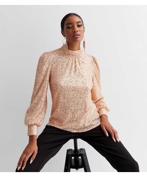 Een klassiek item dat je zeker in je garderobe mag hebben! Onze nieuwe losvallende blouse met hoge hals en pailletten is de juiste keuze als je je garderobe wilt updaten. Of het nu voor een stijlvolle en opvallende feestlook is of voor een netter ensemble, pak deze stijlvolle en verfijnde statementblouse om de aandacht te trekken.