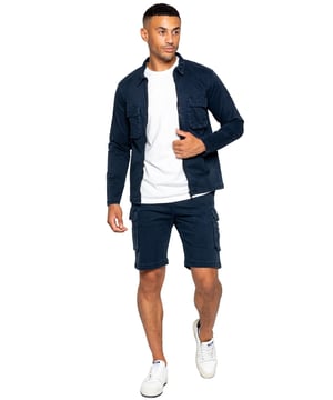Conjunto Enzo Cargo para hombre. Sobrecamisa Cargo de manga larga, con cremallera y cuello. Dos bolsillos delanteros planos con cierre de velcro. Dos bolsillos laterales. Ribetes cosidos en mangas y dobladillo. Se completa con pantalones cortos tipo cargo. Cintura elástica con cordón ajustable. Diseño de 5 bolsillos. 2 bolsillos laterales, 2 bolsillos cargo con cierre de velcro. Bolsillo trasero de ojal. Cintura elástica con cordón ajustable.