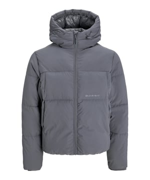 Diese Herren-Steppjacke bietet den perfekten Mix aus Funktionalität und Stil. Die hochschließende Kapuze mit Kordelzug schützt zuverlässig vor Wind und Wetter. Ein durchgehender Reißverschluss mit Kinnschutz sorgt für zusätzlichen Komfort und sicheren Sitz. Die gerippten Ärmelbündchen halten die Wärme im Inneren der Jacke, während die seitlichen Eingrifftaschen Platz für Ihre Essentials bieten. Warm gefüttert und winddicht, ist diese Jacke ideal für kühle Tage. Ein kleiner Label-Print setzt dezente Akzente und unterstreicht das moderne Design. Hergestellt aus hochwertigen Materialien, garantiert sie hohen Tragekomfort. Diese Jacke ist der perfekte Begleiter für den urbanen Look, der Sie auch bei unbeständigem Wetter nicht im Stich lässt. Funktionalität trifft hier auf minimalistischen Stil.