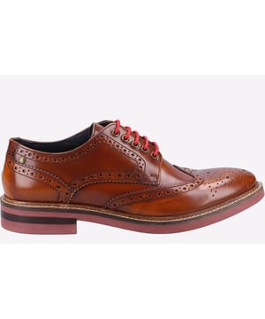 Base London gives you a traditional British derby brogue with a contemporary twist in the Woburn. Hi Shine high quality leather upper with decorative toe detail and a wing tip toe cap. Finished with high quality leather lining and a rubber sole.
- Base London men's traditional British brogue
- Highly popular fashion brogue
- Hi-Shine Leather uppers
- Men's Derby Wingtip
- Contemporary twist to a classic brogue design
- Quality leather lining
- Base London preppy sock with gold print logo
- Fashionable chunky rubber studded sole with rosette branding