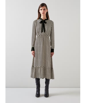 Effortless sophistication with the Bridget graphic print dress in timeless black. This smart casual piece, crafted from high-quality viscose, features a geometric design, adjustable neck tie, and convenient pull-on style. Perfectly pairs with sleek boots or classic heels for a refined look.