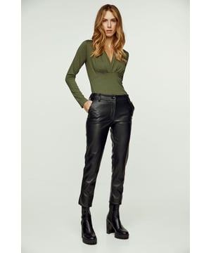 Estos pantalones crop de 7/8 de largo están confeccionados en piel sintética negra. Cintura de 5 cm con trabillas del mismo tejido. Se abrocha por delante con un botón y una cremallera de polipiel. Bolsillos con aberturas diagonales a los lados. En la parte exterior del bajo hay una abertura redondeada. Póntelo con un polo ajustado y unas deportivas para un look casual chic.