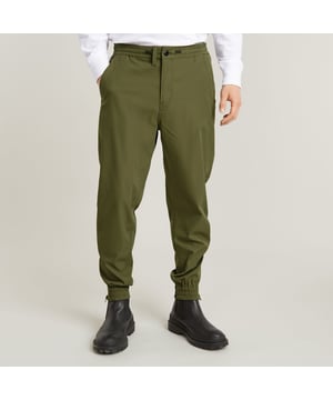 Zip fly, drawcord added. Inset pockets, single back pocket. Stretchable cuffs, relaxed width. Zipper at the lower leg. Pleats inner knee. Zip & button closure. Mid waist. Woven trainer RCT is designed in a loose fit with a relaxed cuff. Inset pockets are combined with a single pocket at the back. The zippers at the ankle add detail. 65% Polyester (Recycled), 35% Elastomultiester. Comfortable stretch. Tapered