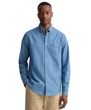 Crafted with Lightweight and Breathable Cotton, these Gant Originals features a Button Down Collar and the Brands Classic Logo on Chest. The Regular Fit Indigo Shirt is a classic preppy essential that will carry you through the warmer months and beyond.