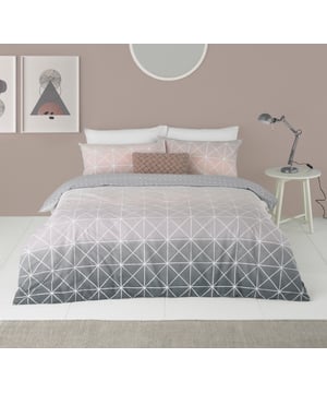 Featuring a gorgeous gradient flowing from a crisp white, to soft pink and finishing on a beautiful grey the Spectrum duvet cover set is a versatile piece. Complete with thin white lines in a geometric pattern it brings a modern touch that will elevate your bedroom into a contemporary space. The reverse has a matching plain grey with white dots to neutralise the statement front. Each duvet set comes with matching pillowcases with a reversible design. Made of crisp polycotton making this duvet set soft and hard-wearing. This duvet cover features a secure button closure while the pillowcases have an envelope closure. Machine washable on a 40 degree cycle. Iron cool and tumble dry on a low setting for the best finish.